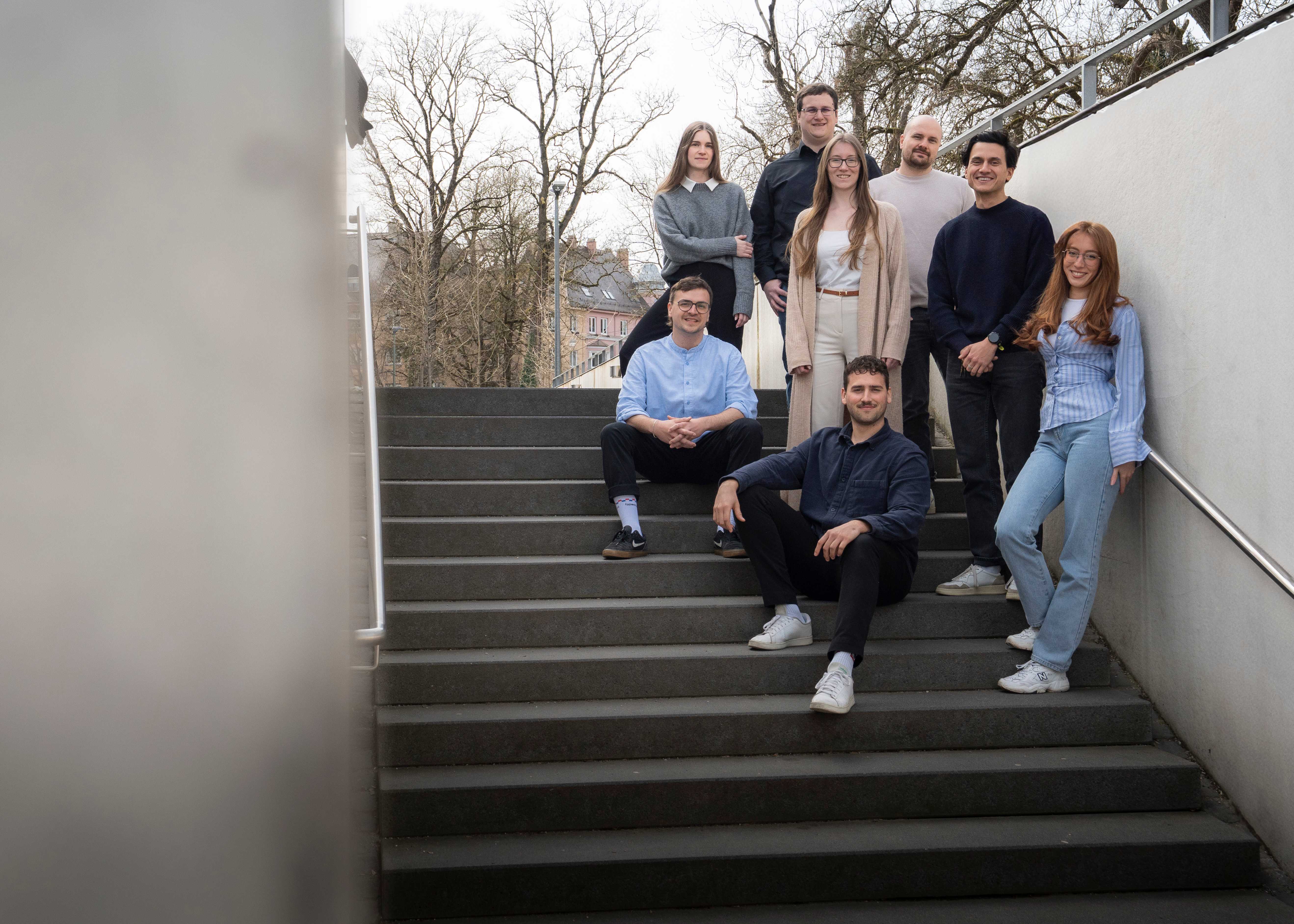 The typedigital-team sitting on a public stair in Augsburg
