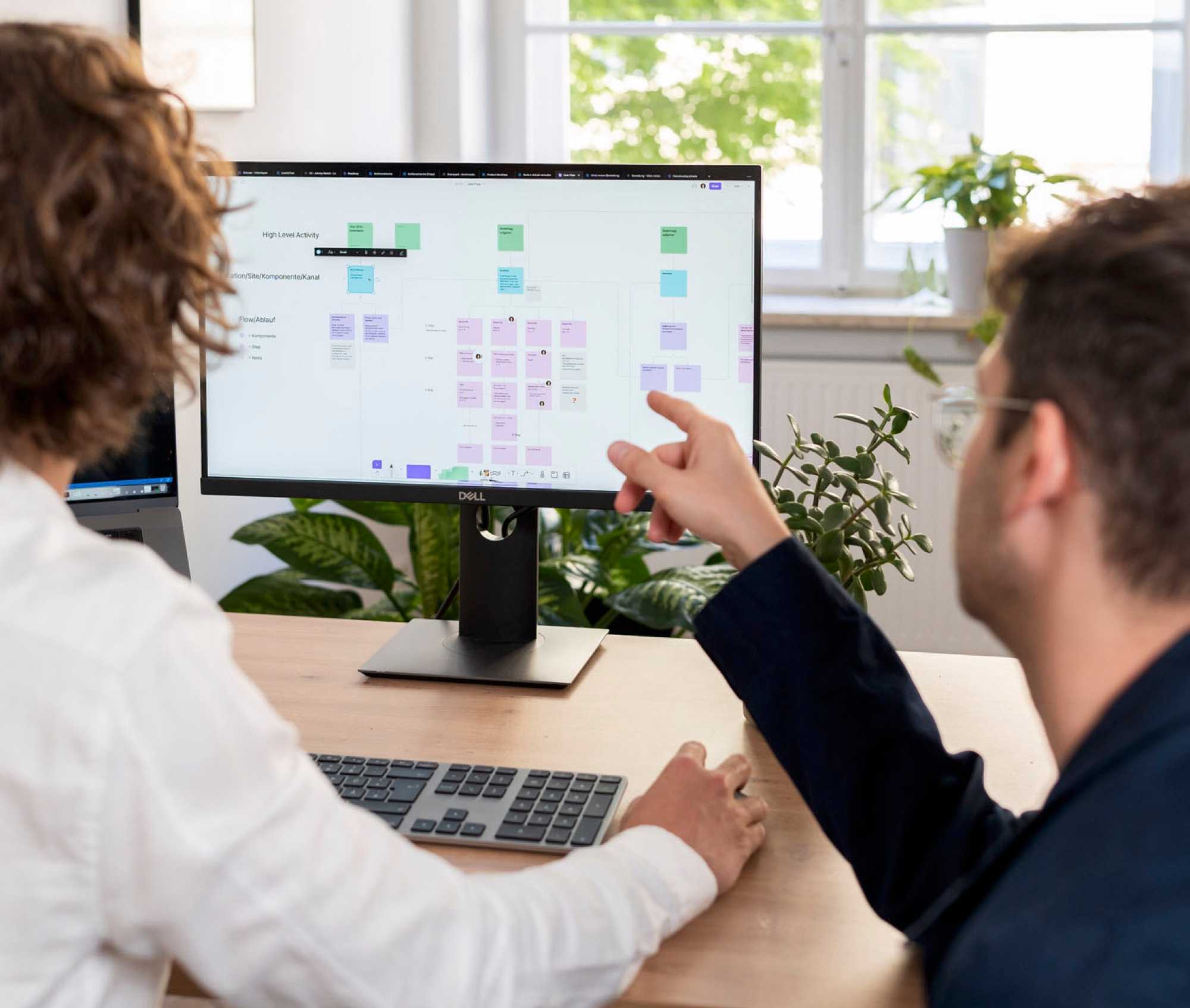 Employee Kalle shows UX Designer Johnny something on the screen.