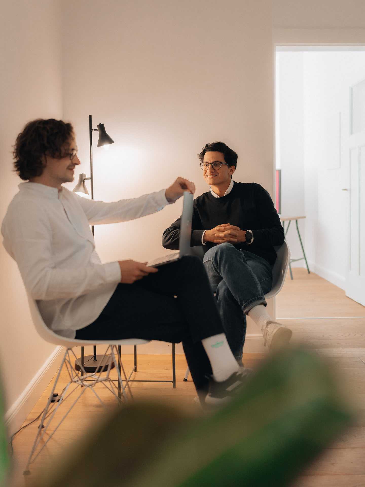 Zwei Personen sitzen auf Stühlen und unterhalten sich.